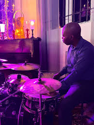 Sipho behind the kit in purple stage light